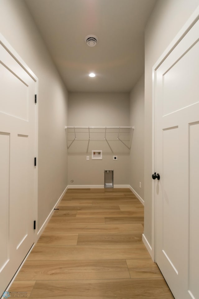 laundry area featuring light wood-type flooring, electric dryer hookup, baseboards, washer hookup, and visible vents