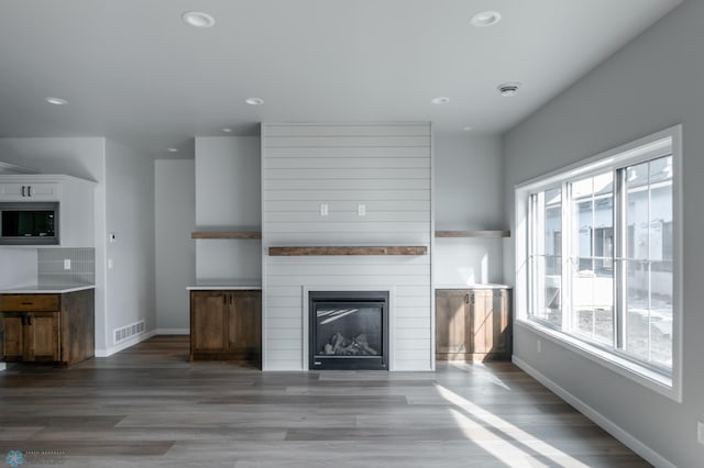 unfurnished living room with baseboards, recessed lighting, and wood finished floors