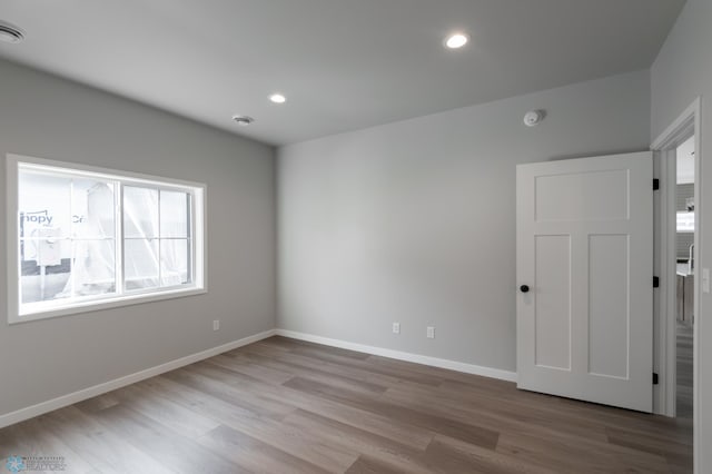 unfurnished room featuring recessed lighting, visible vents, baseboards, and wood finished floors