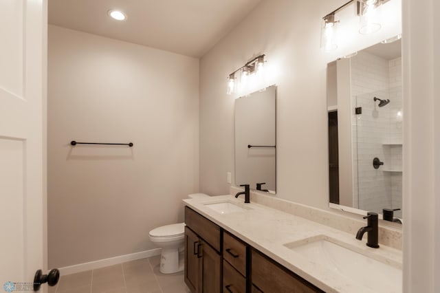 bathroom featuring tiled shower, baseboards, a sink, and toilet