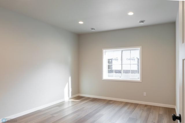 spare room featuring recessed lighting, light wood-style flooring, and baseboards