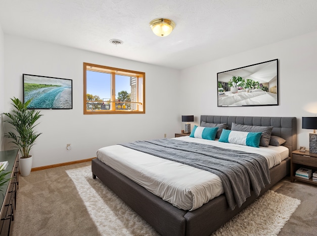 bedroom with light carpet, baseboards, and visible vents