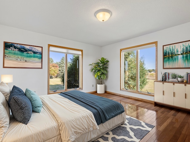 bedroom with baseboards and hardwood / wood-style flooring