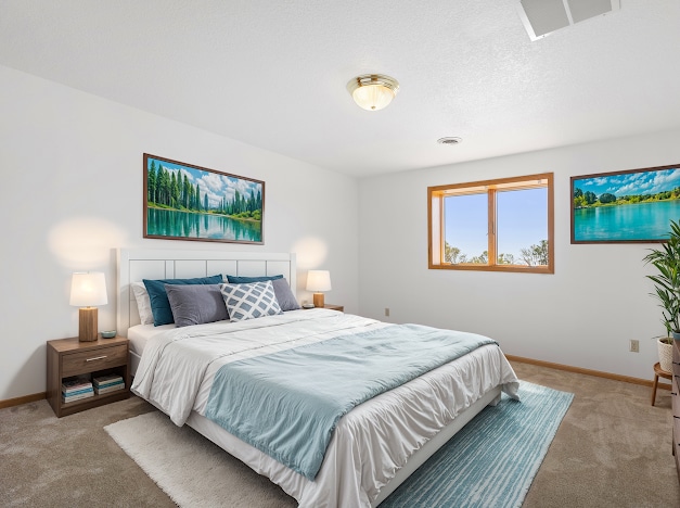 bedroom with visible vents, baseboards, and light colored carpet