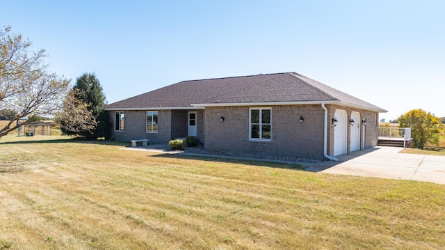 single story home with a front yard, a garage, concrete driveway, brick siding, and roof with shingles