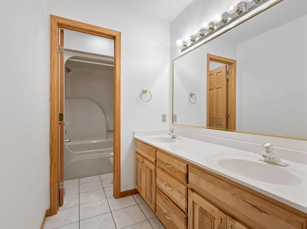 bathroom with tile patterned flooring, double vanity, a sink, and toilet