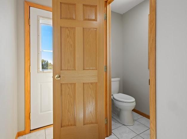 bathroom with toilet, tile patterned flooring, and baseboards