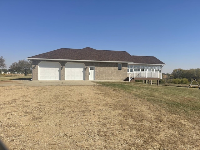 view of front of house featuring driveway, an attached garage, a front lawn, brick siding, and a shingled roof