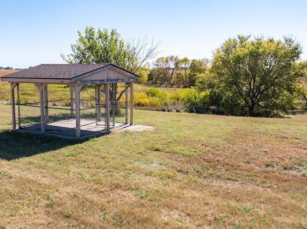 view of yard featuring an exterior structure, a carport, and an outbuilding