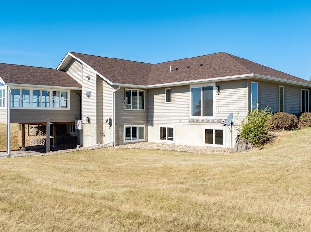 rear view of house featuring a yard
