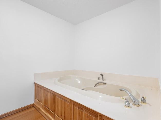 bathroom with baseboards and wood finished floors