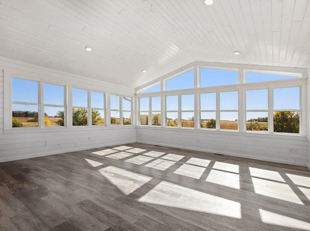 unfurnished sunroom featuring wooden ceiling, wooden walls, recessed lighting, wood finished floors, and lofted ceiling