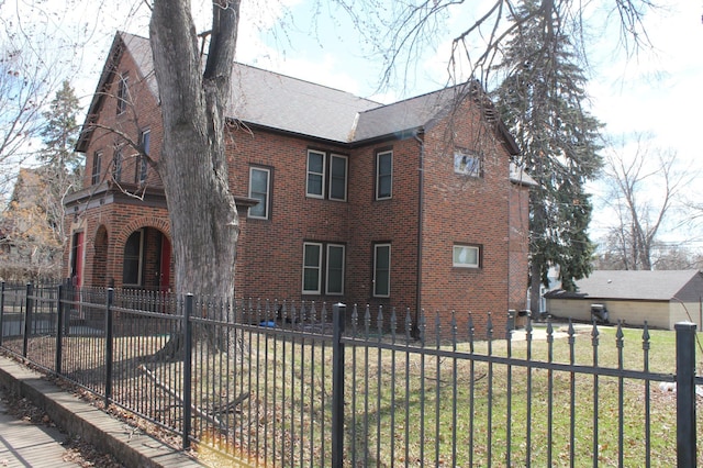 696 Hawthorne Ave E, Saint Paul, MN 55106 - view of front of property with brick siding, fence private yard, roof with shingles, and a front yard