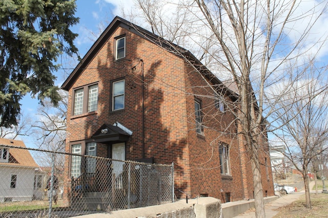 696 Hawthorne Ave E, Saint Paul, MN 55106 - view of front facade with brick siding and fence private yard