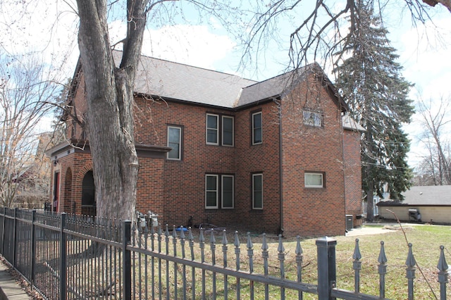 696 Hawthorne Ave E, Saint Paul, MN 55106 - view of property exterior with brick siding, a shingled roof, and a fenced front yard