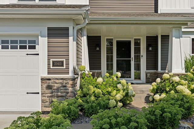 20413 Everton Trl N, Forest Lake, MN 55025 - view of exterior entry with a porch, stone siding, a garage, and a balcony
