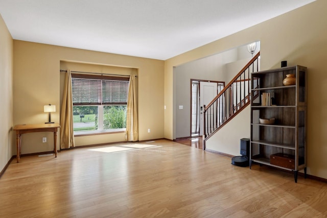 20413 Everton Trl N, Forest Lake, MN 55025 - unfurnished living room featuring stairway, baseboards, and wood finished floors