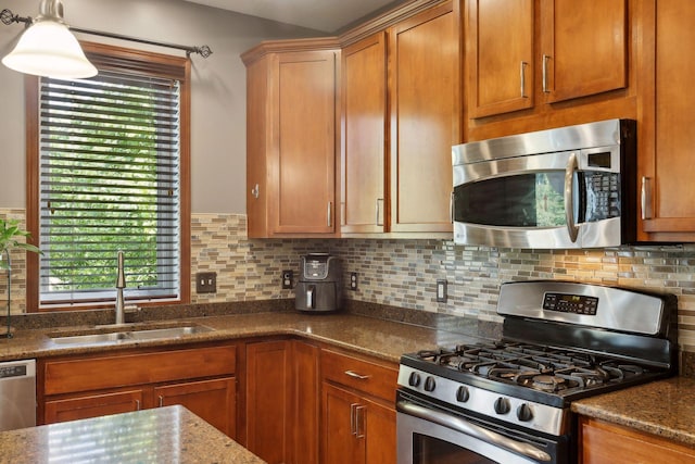 20413 Everton Trl N, Forest Lake, MN 55025 - kitchen with dark stone counters, brown cabinetry, a sink, stainless steel appliances, and backsplash