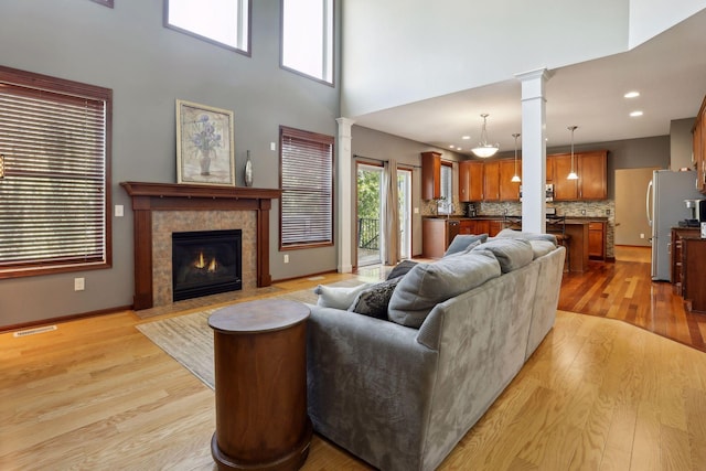 20413 Everton Trl N, Forest Lake, MN 55025 - living room with light wood-style floors, visible vents, decorative columns, and a tile fireplace