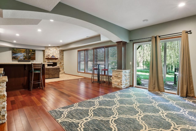 20413 Everton Trl N, Forest Lake, MN 55025 - living room featuring ornate columns, arched walkways, hardwood / wood-style flooring, and a fireplace