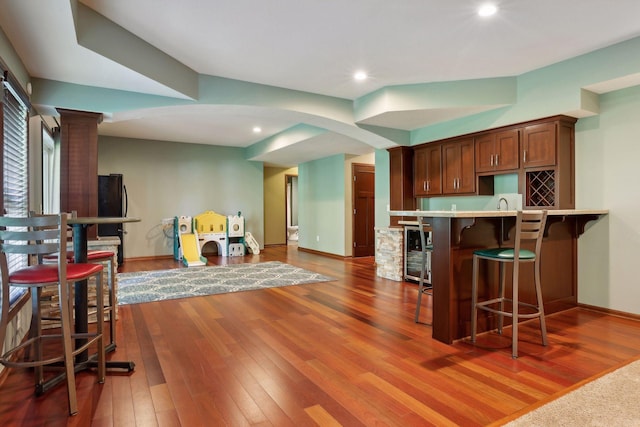 20413 Everton Trl N, Forest Lake, MN 55025 - kitchen with light countertops, a kitchen bar, dark wood finished floors, wine cooler, and ornate columns