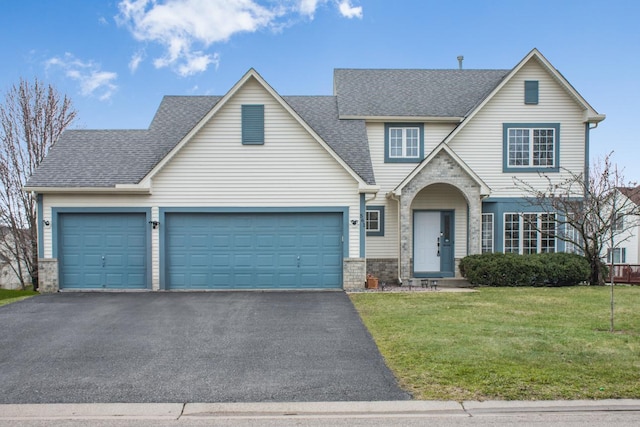 traditional-style home with roof with shingles, an attached garage, stone siding, a front yard, and driveway