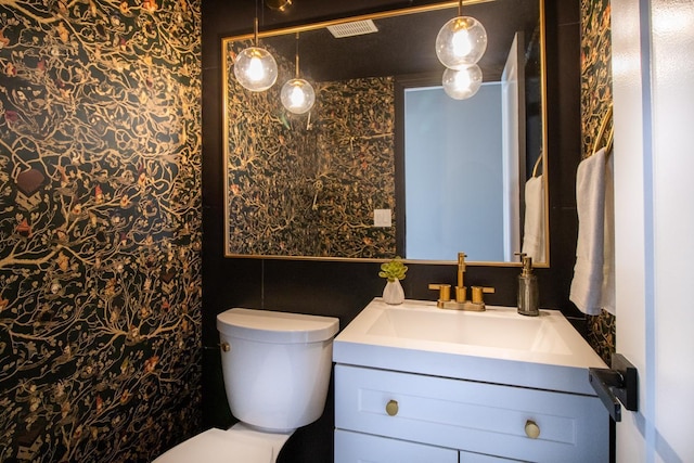 bathroom featuring toilet, visible vents, and vanity