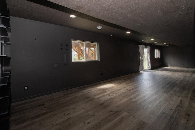spare room featuring recessed lighting, a textured ceiling, and wood finished floors