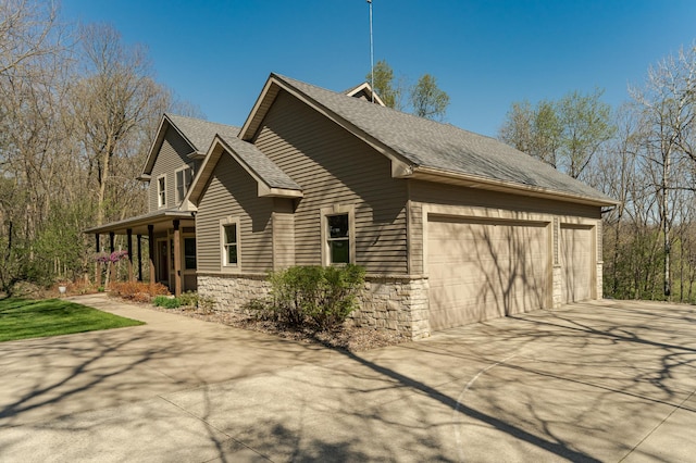 1125 Riverwood Dr SW, Oronoco, MN 55960 - view of home's exterior featuring stone siding, driveway, and a shingled roof