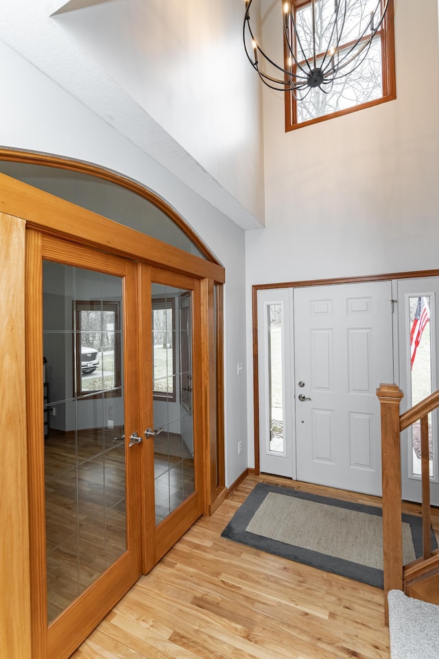 1125 Riverwood Dr SW, Oronoco, MN 55960 - entryway featuring a chandelier, french doors, wood finished floors, healthy amount of natural light, and a towering ceiling