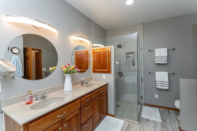 1125 Riverwood Dr SW, Oronoco, MN 55960 - bathroom with double vanity, a stall shower, toilet, and baseboards