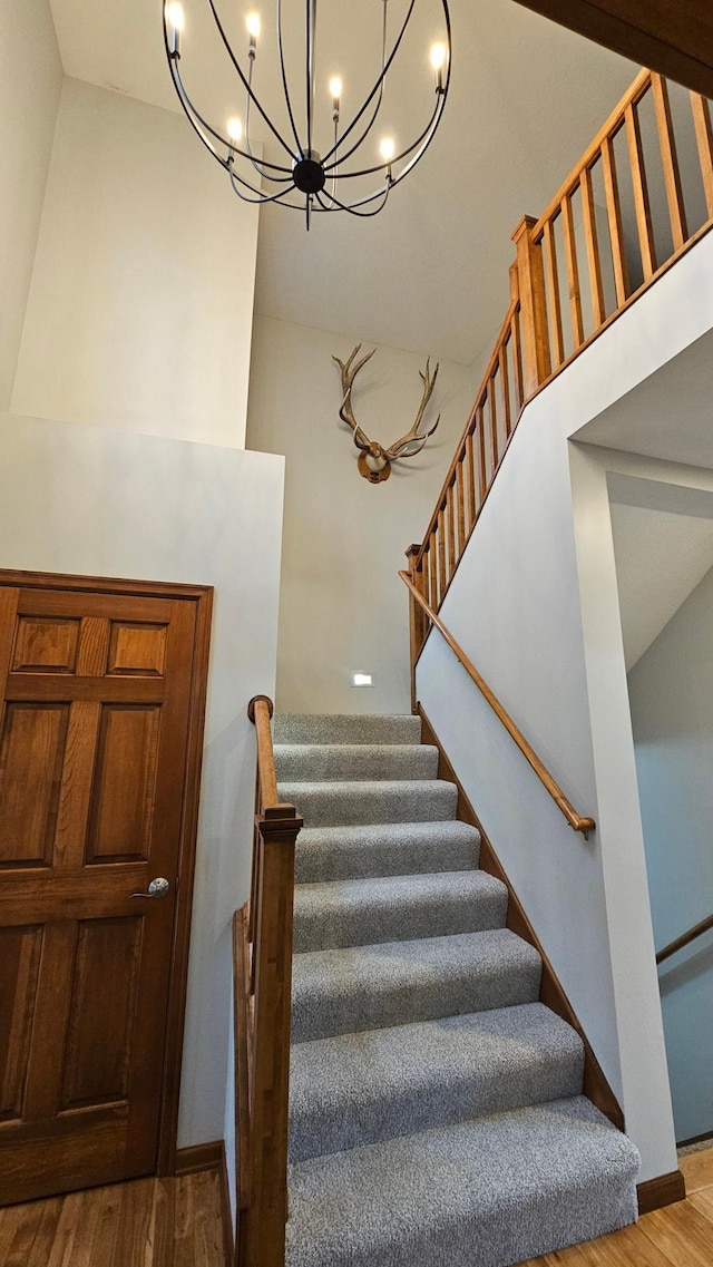 1125 Riverwood Dr SW, Oronoco, MN 55960 - staircase featuring wood finished floors, a chandelier, and baseboards