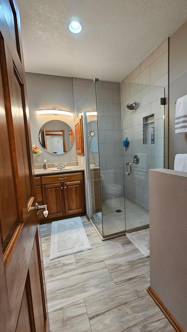 1125 Riverwood Dr SW, Oronoco, MN 55960 - bathroom featuring a textured ceiling, vanity, a shower stall, and recessed lighting