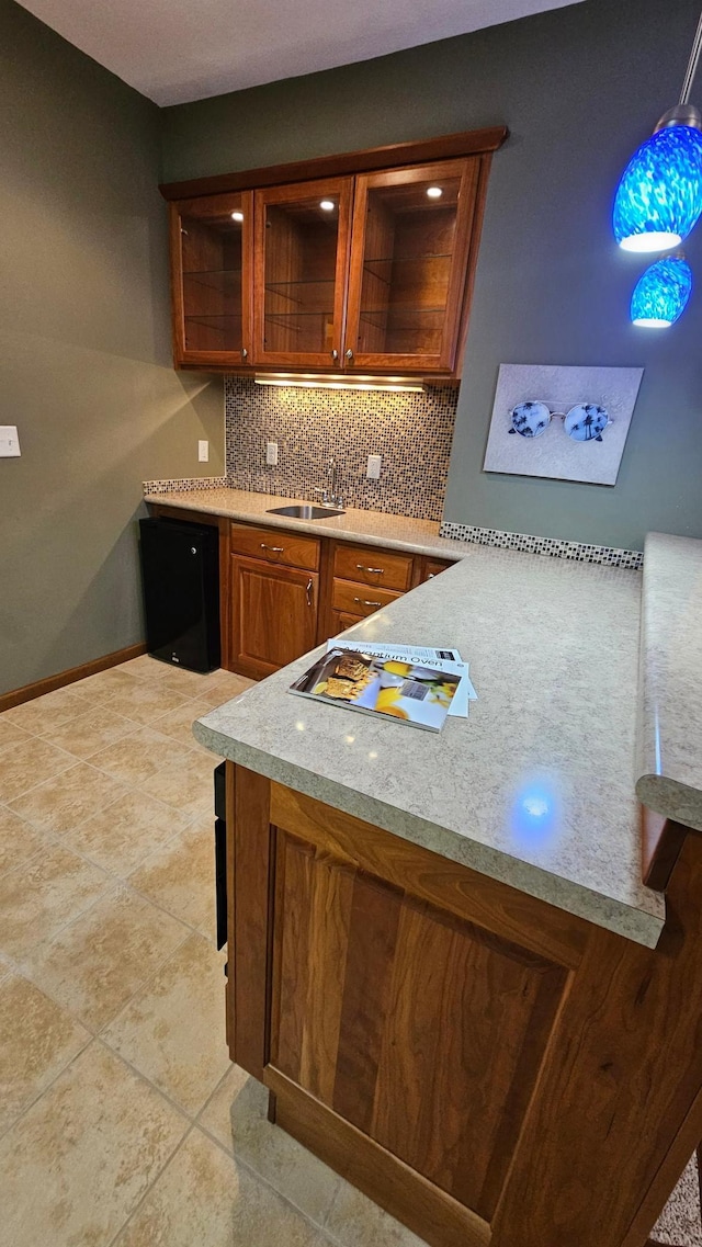 1125 Riverwood Dr SW, Oronoco, MN 55960 - bar area featuring backsplash, a sink, dishwasher, baseboards, and light tile patterned flooring