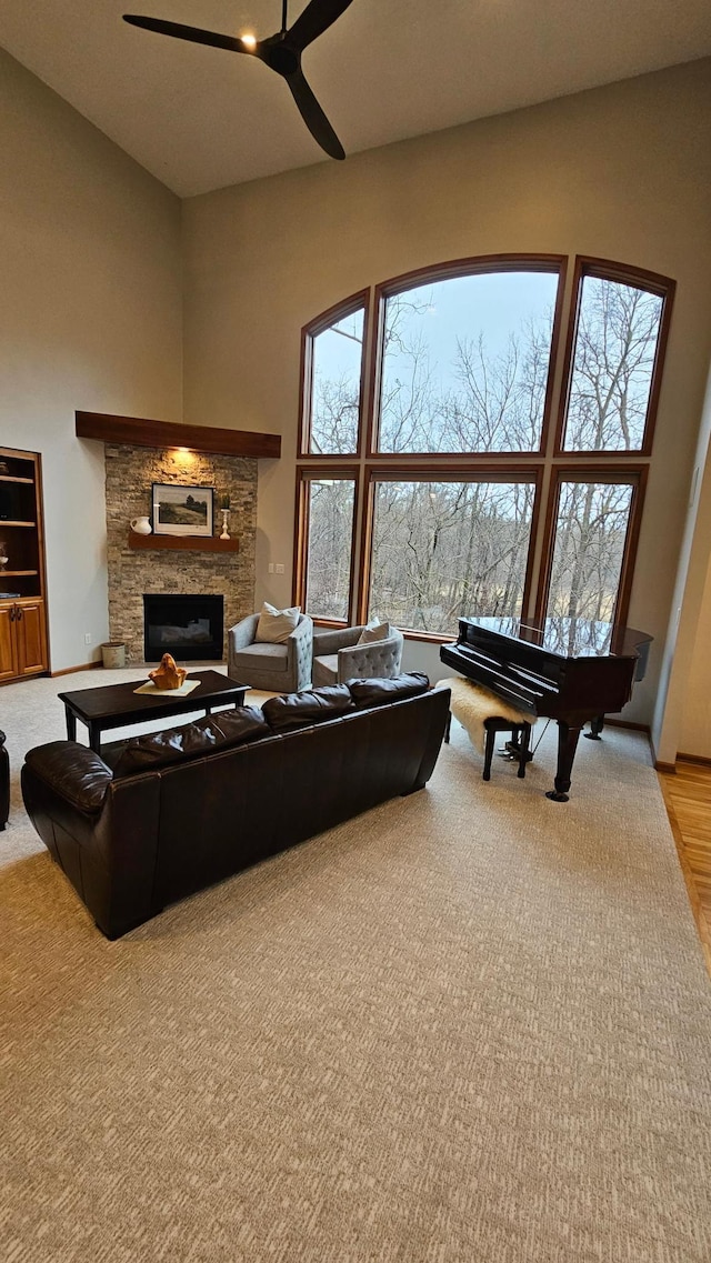 1125 Riverwood Dr SW, Oronoco, MN 55960 - living area featuring ceiling fan, a towering ceiling, a fireplace, and wood finished floors