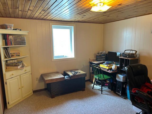 home office with wood ceiling and light colored carpet