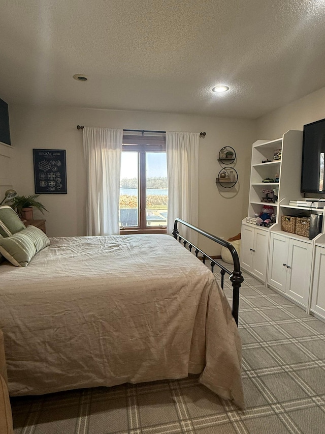 bedroom with light carpet, a textured ceiling, and recessed lighting