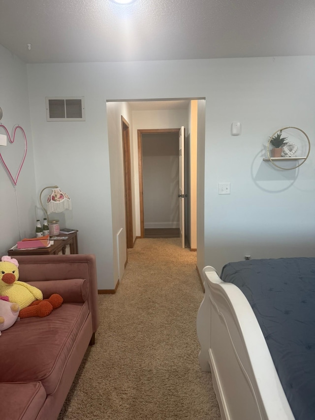 hallway with light colored carpet, baseboards, and visible vents