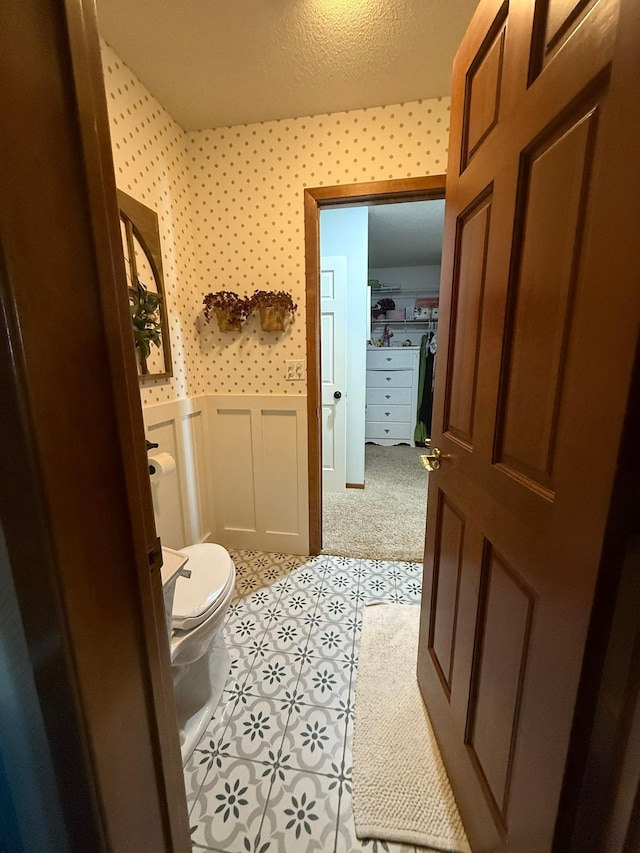 bathroom with toilet and wainscoting