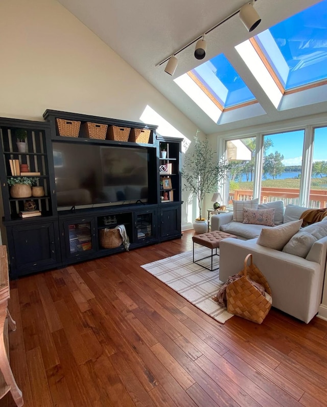 living area with lofted ceiling with skylight, rail lighting, and hardwood / wood-style floors