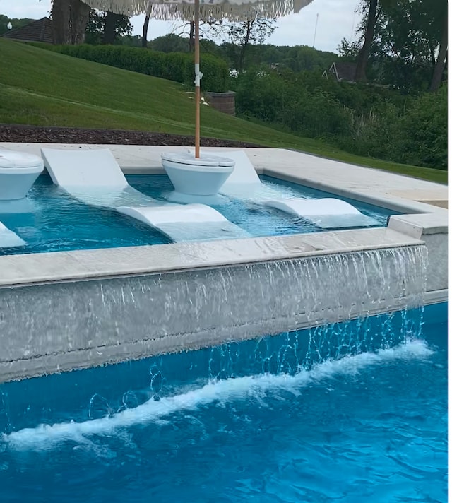 outdoor pool featuring a jacuzzi and a yard