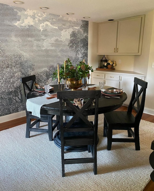 dining space featuring baseboards and wood finished floors