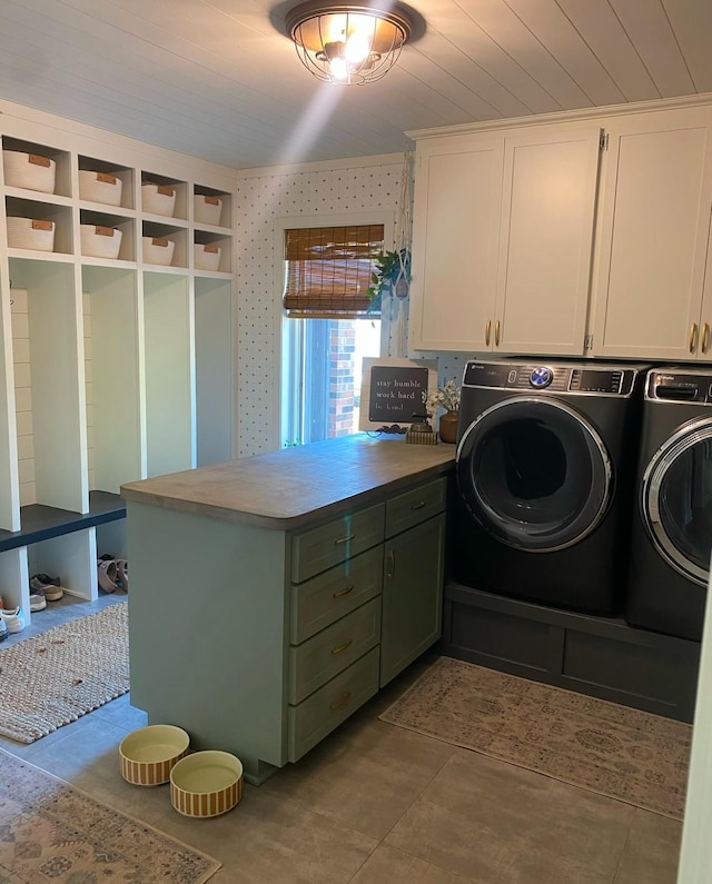 clothes washing area featuring washing machine and clothes dryer and cabinet space