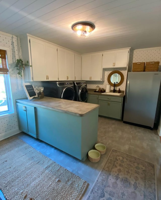 clothes washing area with separate washer and dryer, a sink, and laundry area