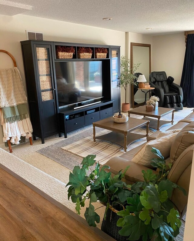 living room featuring a textured ceiling, wood finished floors, and visible vents