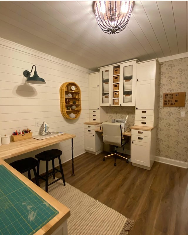 office area with wallpapered walls, built in desk, a chandelier, baseboards, and dark wood-style flooring