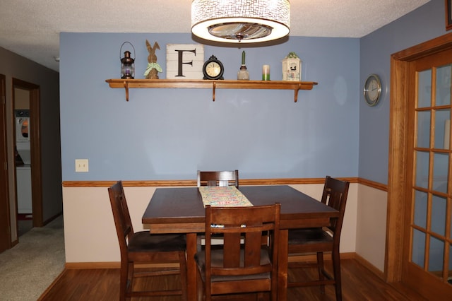 dining space with wood finished floors, a textured ceiling, and baseboards