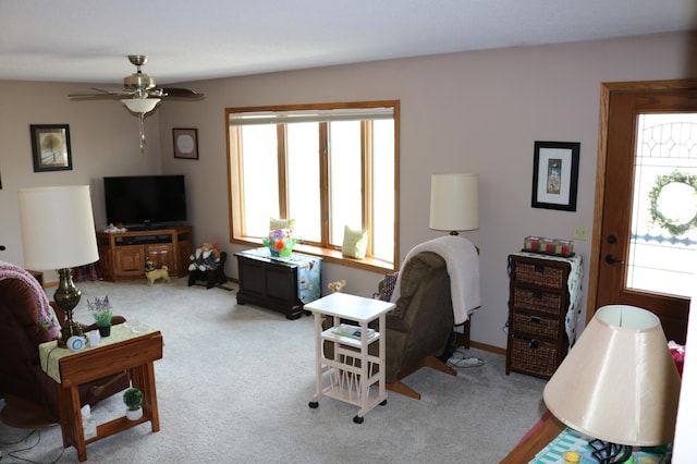 living area featuring a ceiling fan and light colored carpet