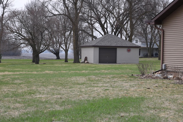 view of grassy yard featuring an outdoor structure and a detached garage