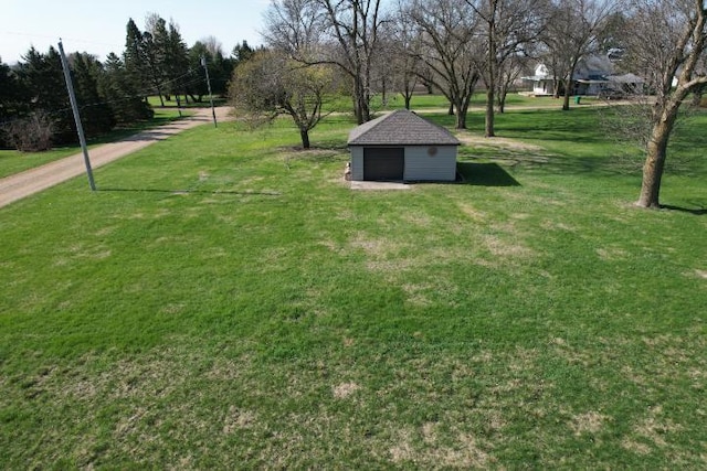 view of green lawn with an outbuilding and a garage